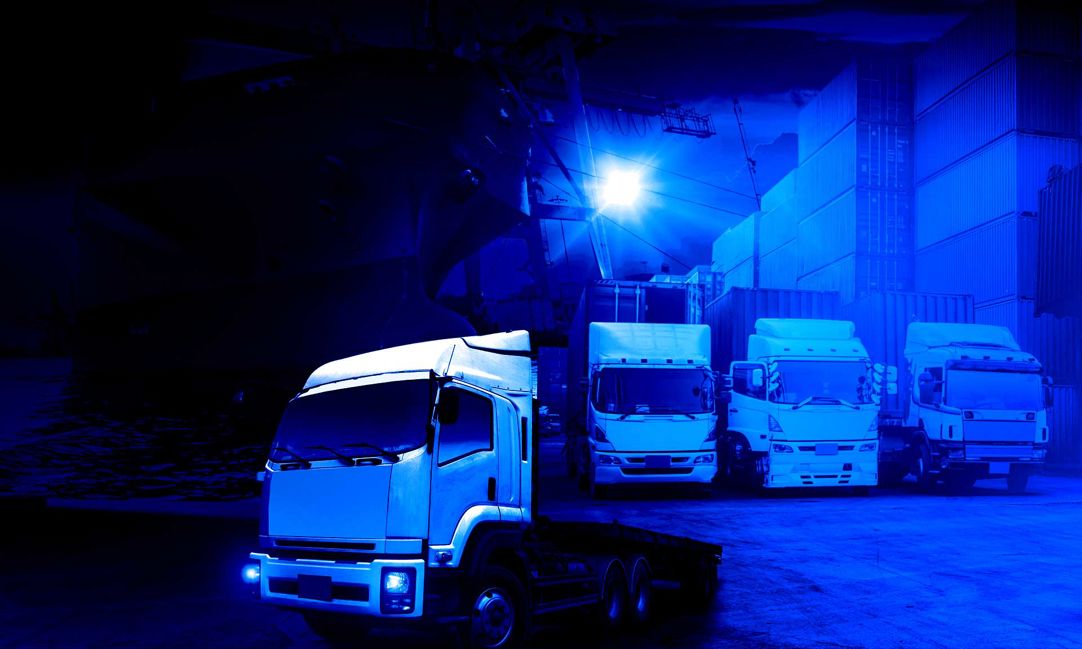 blue tinted composite of semi trucks, cargo ships, and planes.